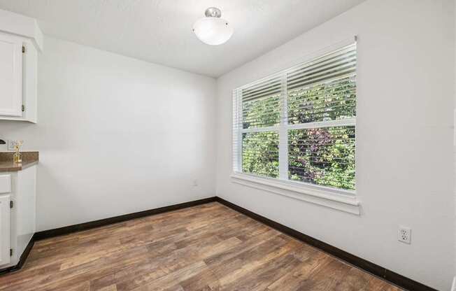 A room with a window and wooden flooring.