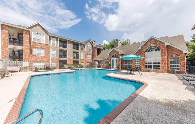 A swimming pool in front of a brick building.
