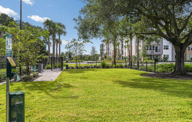 A green sign is on a post in a grassy area.