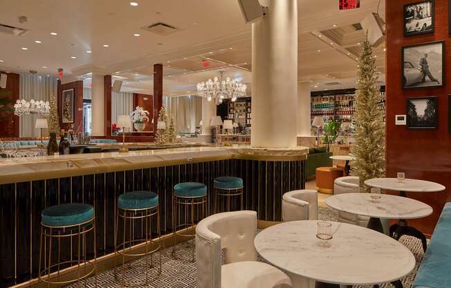 A bar with white stools and a gold bar top.