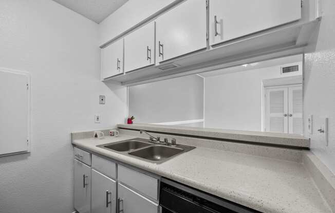 the kitchen of our studio apartment atrium with white cabinets and a sink