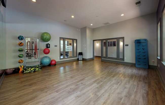 a large fitness room with hardwood floors and a large window at Autumn Park Apartments, Charlotte