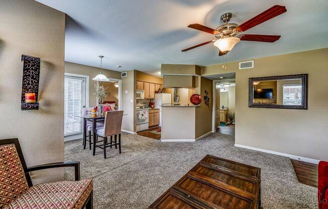 a living room with a ceiling fan and a dining room and kitchen