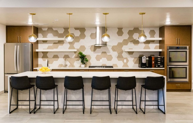 a kitchen with a large island with black chairs