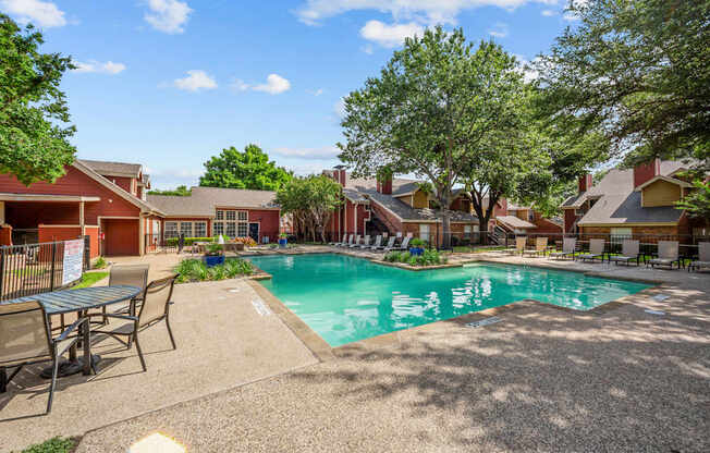 A pool surrounded by chairs and trees in a sunny day.