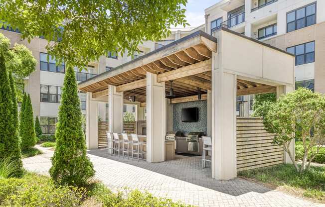 a patio with a grill and a table and chairs