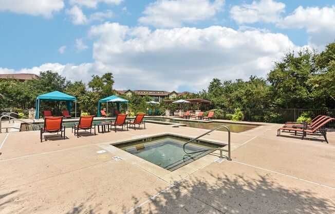 the reserve at the falls pool and hot tub with chairs and umbrellas at Lakeline East Apartments, Cedar Park