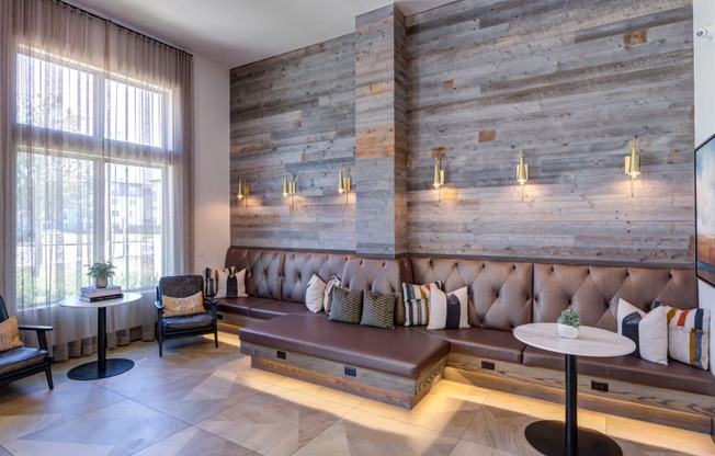 a lobby with couches and tables and a wall with reclaimed wood