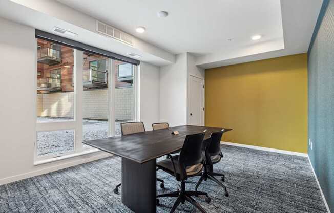 A conference room with a table and chairs.