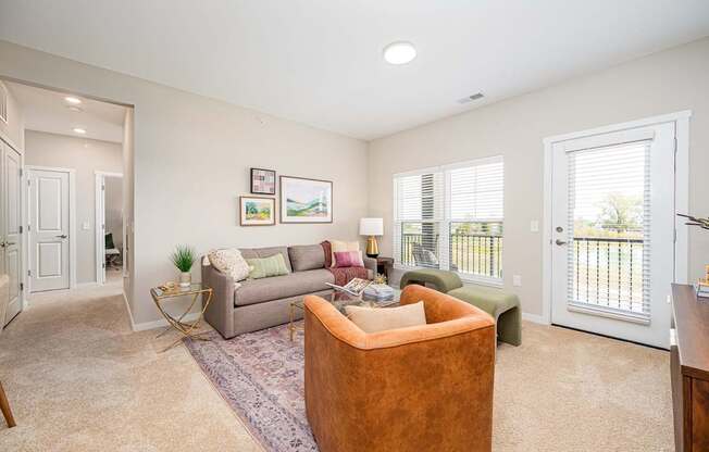 A living room with a couch, chair, and pictures on the wall.