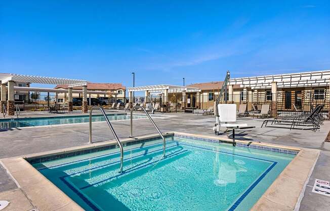 A large outdoor swimming pool with a diving board and a sun lounger.