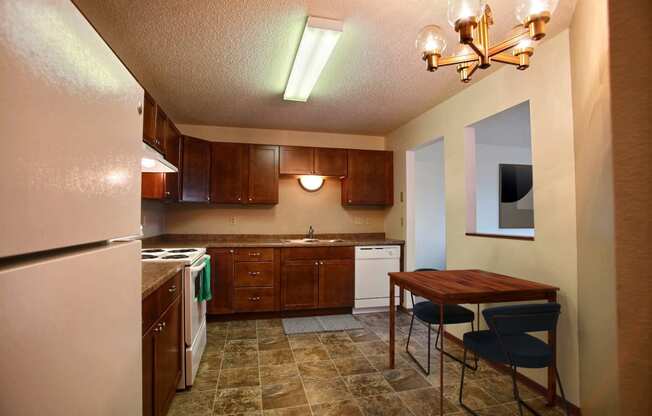 a kitchen with white appliances and wooden cabinets. Fargo, ND Westwood Estates Apartments