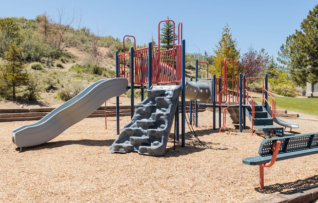 a playground with slides and benches in a park