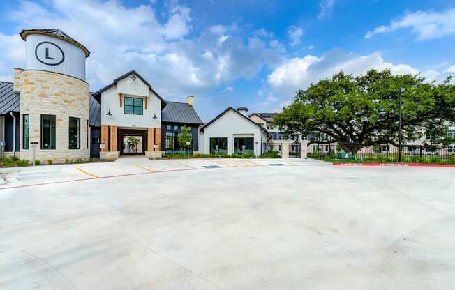 an empty parking lot in front of a building with trees at Legacy at Cibolo, Boerne, TX