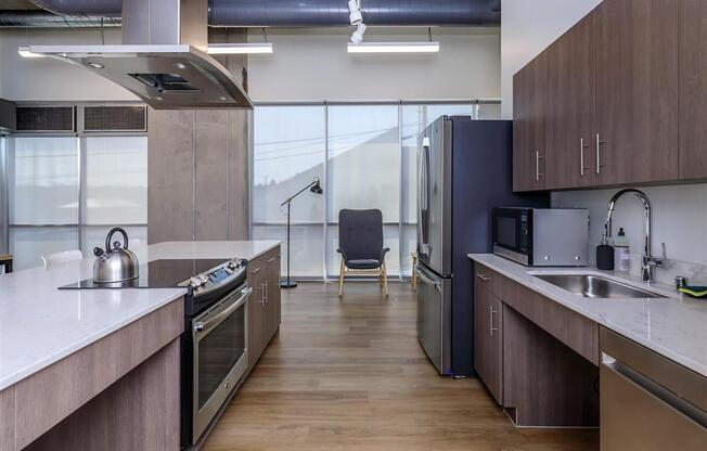 a kitchen with a stove top oven next to a sink at Jefferson Yards, Tacoma, WA