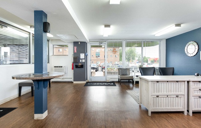 a community room with a table and chairs and a large window