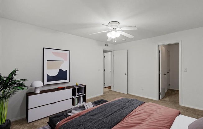 a bedroom with a bed and a ceiling fanat Millcreek Woods Apartments, Olathe