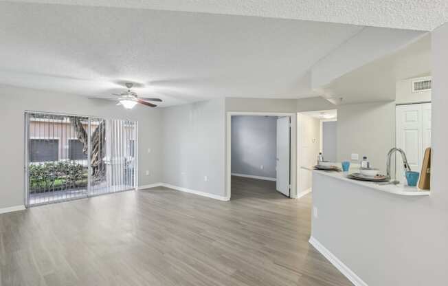 an open living room and kitchen with a sliding glass door to a patio at Pembroke Pines Landings, Pembroke Pines, Florida, 33025