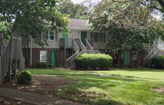 an apartment building with stairs and green doors