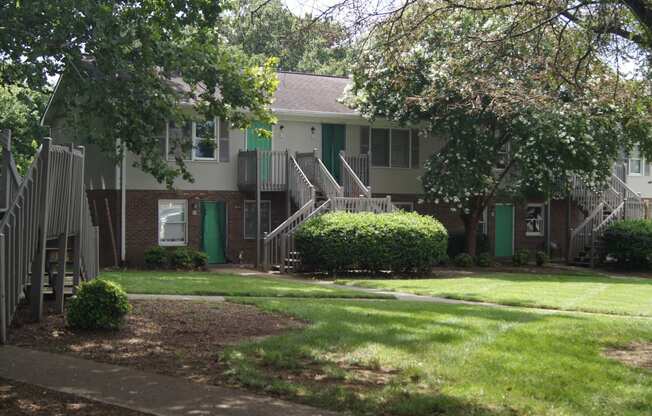an apartment building with stairs and green doors