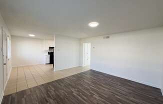 an empty living room with white walls and wood flooring