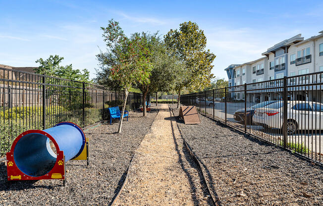A playground with a blue slide and a red and yellow slide.