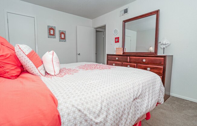 Model apartment bedroom with a bed, dresser, and mirror at Laurel Parc apartments in Shreveport, LA.