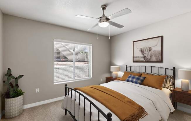 the bedroom of a home with a bed and a ceiling fan