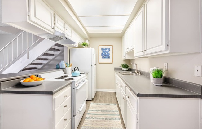 a kitchen with white cabinets and a white stove top oven