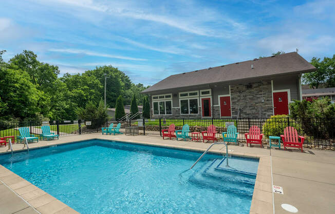 Retreat at Indian Lake Apartments Hendersonville TN swimming pool with red chairs and a building in the background.