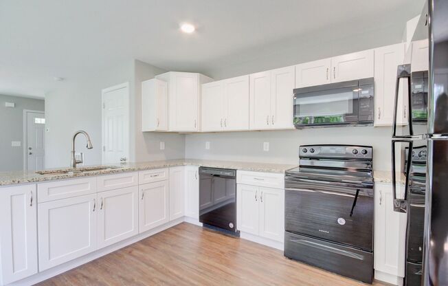 Two Story Duplex With Hardwood Flooring and White Cabinetry