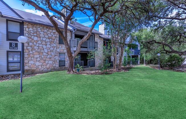 a house with a lawn in front of a brick building