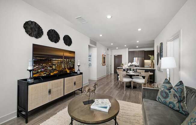 Stylish living space with soft textures, a sleek media console, and wide windows for abundant light