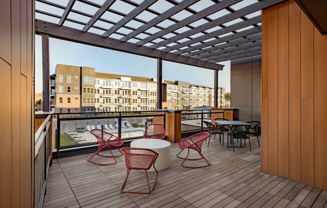a rendering of a balcony with red chairs and tables