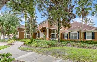 A row of houses with trees in front.