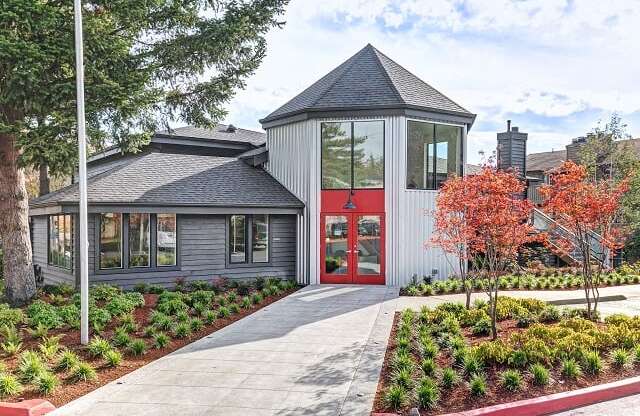 Exterior of Hangar 128 Apartment Homes with turret style architecture and a red door at Hangar 128 Apartments Homes in Everett, WA