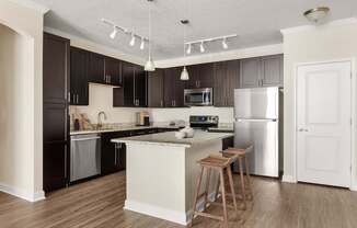 A kitchen with a white island and a white refrigerator.