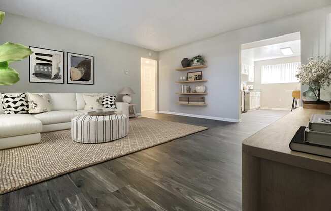 A living room with a white sofa and a wooden floor.