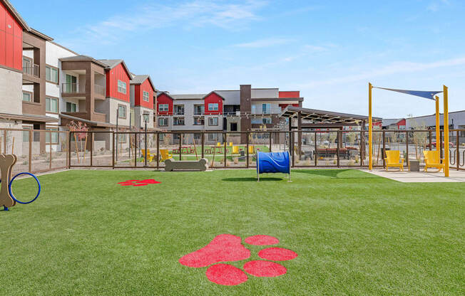 A playground with a blue tarp and red flower pattern on the grass.