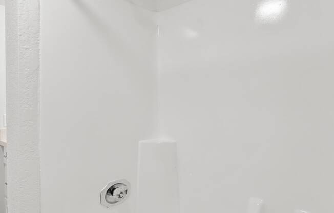 a white bathroom with a tub and a shower curtain