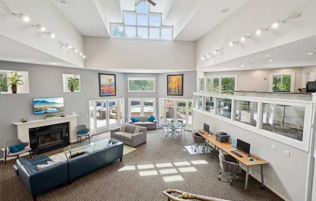 A spacious room with a fireplace, couches, and a ceiling fan.