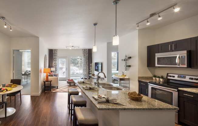 a kitchen and living room with a large granite counter top