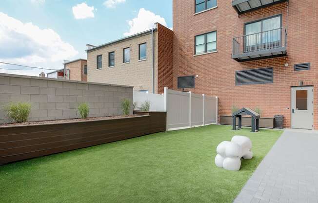 the back yard of a house with artificial grass and a fence
