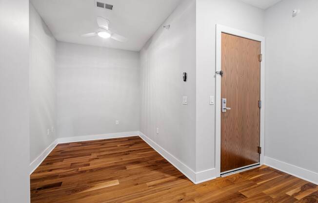 a bedroom with wood flooring and a door to a closet