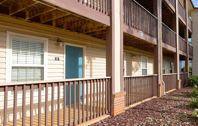 a porch of an apartment building with a blue door