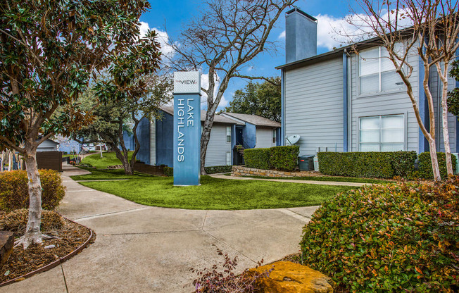 a sidewalk with a blue welcome sign in front of a house