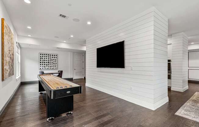 A room with a white wall and a black television.
