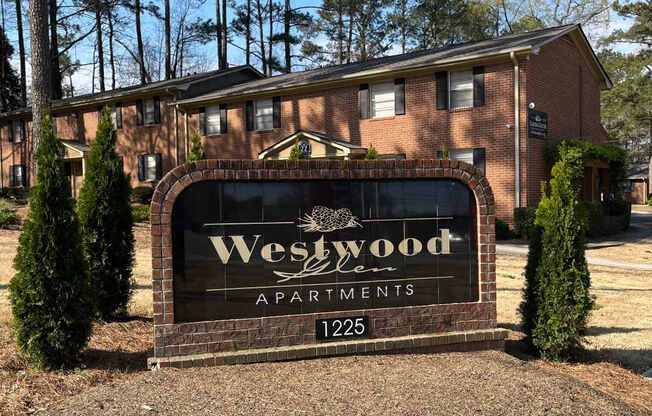 A sign for Westwood Apartments is in front of a building.