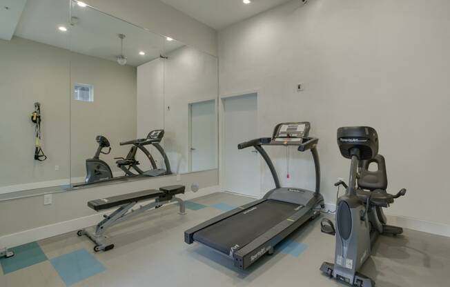 a gym with two treadmills and two elliptical machines