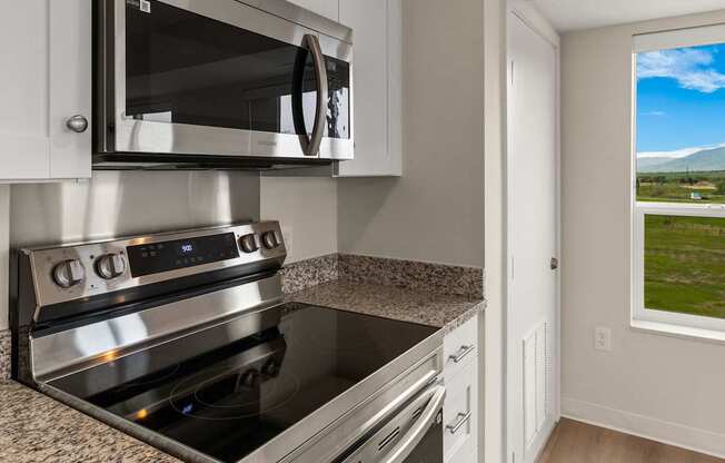A modern kitchen with a stainless steel oven and microwave.